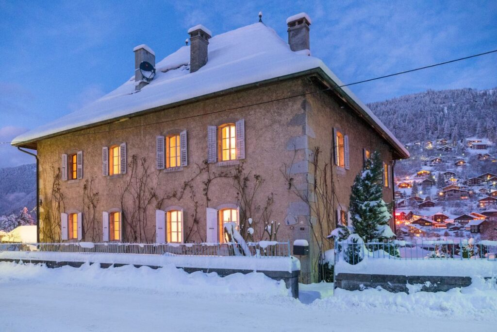Le Manoir exterior Le Manoir at night in the snow in Morzine town center