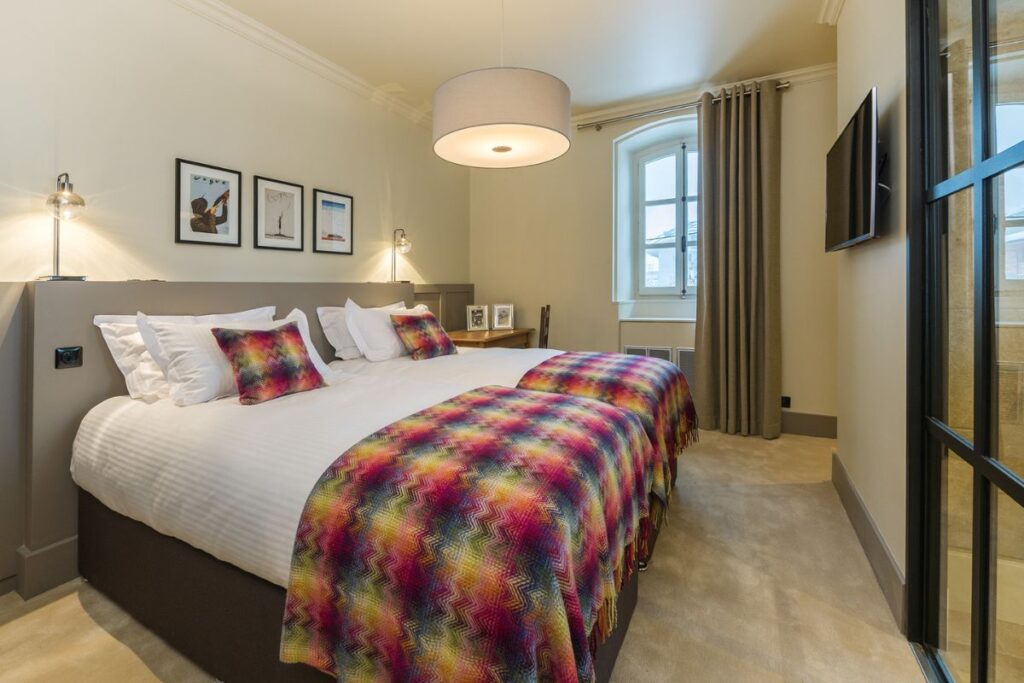 Room 5 Double ensuite bedroom at Le Manoir in Morzine with colourful bedding and natural light