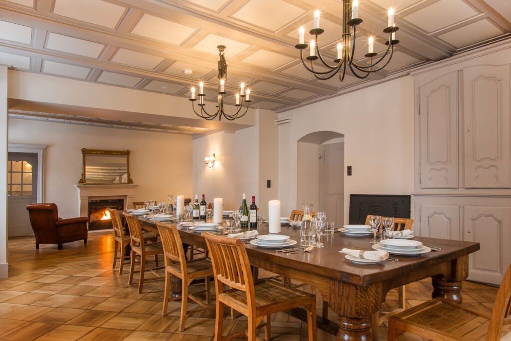 Le Manoir Dining Room Le Manoir Morzine dining room set for a catered chalet dinner with long wooden table and chandeliers