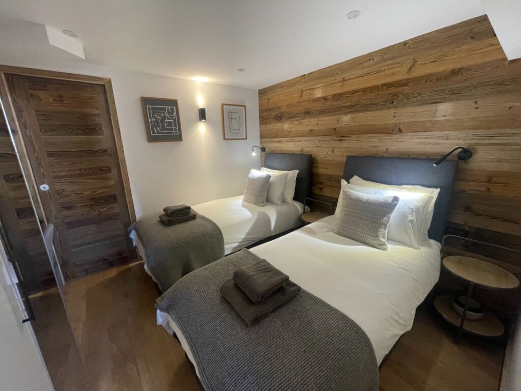 Room 2 Le Petit Cham twin or double ensuite bedroom with wood-panelled feature wall